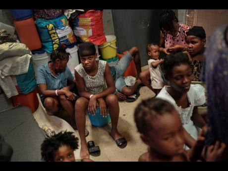 A youth looks into the camera inside a school-turned-shelter created about a month ago for families displaced by gang violence in Petion Ville in Port-au-Prince, Haiti.