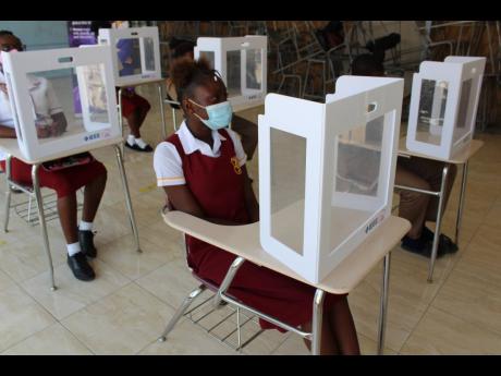 Students of Denham Town High School with desk shields on their desks donated by IEEE Women in Engineering Jamaica Section.