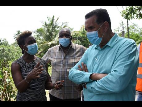 Minister of State Homer Davis (right) listens keenly to St Andrew West Rural Member of Parliament Juliet Cuthbert-​Flynn during a tour of Lawrence Tavern on Wednesday. Looking on is Councillor John Myers. Davis, in an interview with The Gleaner, said tha