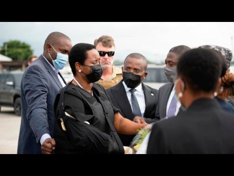 Haiti’s first lady Martine Moise, wearing a bullet proof vest and her right arm in a sling, arrives at the Toussaint Louverture International Airport in Port-au-Prince, Haiti yesterday.