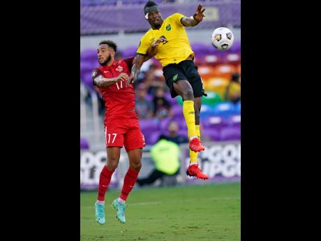 Jamaica forward Cory Burke (right) outjumps Guadeloupe defender Anthony Baron to the ball during the first half of their Concacaf Gold Cup Group C match at Exploria Stadium in Orlando, Florida, on Friday.