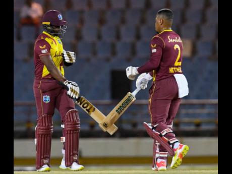 West Indies batsmen Dwayne Bravo (left) and Shimron Hetmyer celebrate a boundary during their second Twenty20 International match against Australia in Gros Islet, St Lucia, on Saturday, July 10.