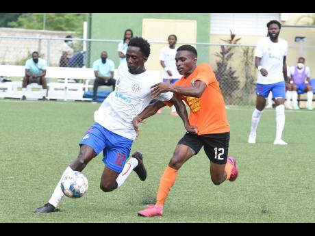 Credit: Kenyon Hemans Portmore United goalscorer Jevick McFarlane evades a challenge from Tivoli Gardens' Andre Smith during their Jamaica Premier League game at the UWI/JFF Captain Horace Burrell Centre of Excellence on Monday.