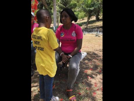 Credit: Contributed Head of the Community Safety and Security Branch for the St James Police, Deputy Superintendent of Police Yvonne Whyte-Powell, engages with a participant in the 2019 Literacy Summer Camp held at the Salt Spring Primary and Infant School in St James.