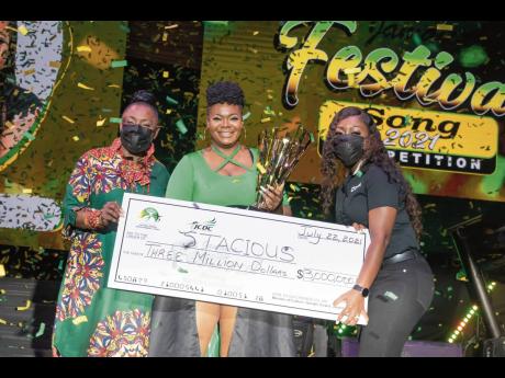 Minister of Culture, Gender, Entertainment and Sport Olivia ‘Babsy’ Grange (left), and Digicel Brand Marketing Manager Reshima Kelly-Williams (right) hand over the grand prize of $3 million to an overjoyed Stacious, winner of the 2021 Jamaica Festival 
