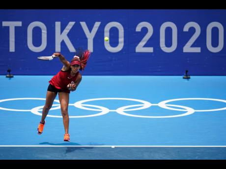Naomi Osaka, of Japan, serves to Viktorija Golubic, of Switzerland, during the second round of the tennis competition at the 2020 Summer Olympics in Tokyo, Japan on Monday.