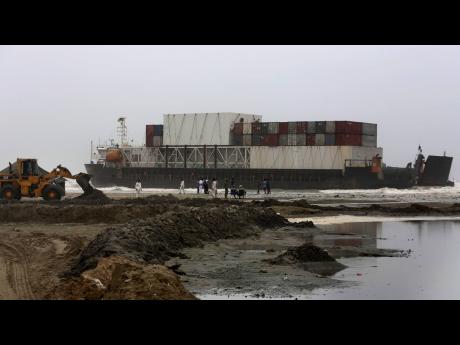 Officials of the Karachi Port Trust and Pakistan Navy prepare to conduct an operation for refloating the stranded Heng Tong 77 cargo ship at Sea View Beach near the southern port city of Karachi, Pakistan, Monday, July 26, 2021. Pakistani authorities said 
