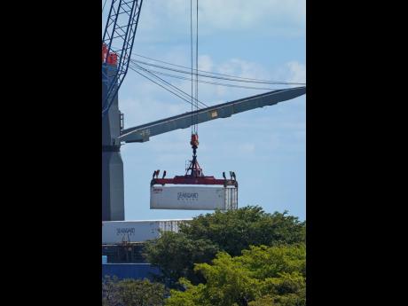 
In this April 9, 2021 photo, a cargo container is unloaded from a ship docked at PortMiami in Miami, Florida.