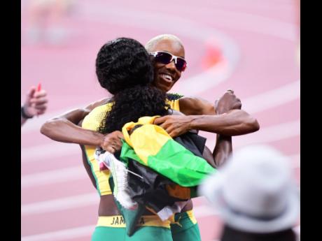 Credit: Gladstone Taylor Shericka Jackson (back to camera) and Candice McLeod embrace as they celebrate their win in the women’s 4x400 metres relay final at the Tokyo 2020 Olympic Games yesterday.