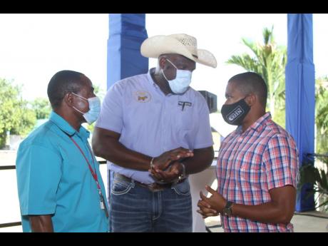 Credit: Nathaniel Stewart Agriculture Minister Floyd Green (right) in discussion with goat farmers at the GOAT seminar, held at the Denbigh Agricultural Showground in Clarendon on Wednesday, August 4.
