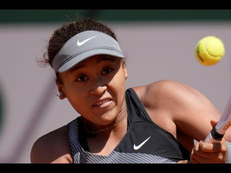 Japan’s Naomi Osaka returns the ball to Romania’s Patricia Maria Tig during their first-round match of the French Open tennis tournament at the Roland Garros stadium in Paris. Osaka withdrew from the French Open and wrote on Twitter that she would be t