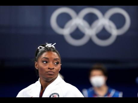 Simone Biles of the United States watches gymnasts perform after she exited the team final at the 2020 Summer Olympics in Tokyo. Biles and Naomi Osaka are prominent, young black women under the pressure of a global Olympic spotlight that few human beings e
