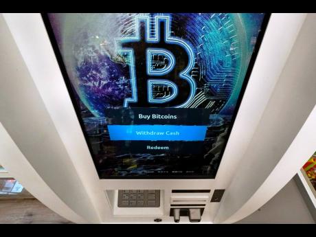 The bitcoin logo appears on the display screen of a cryptocurrency ATM at the Smoker’s Choice store in Salem, New Hampshire.