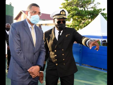 Credit: Kenyon Hemans/Photographer Prime Minister Andrew Holness (left) is given a tour of the ‘Jamaica III’’ by Captain Hugh Helps after it was commissioned into service yesterday.
