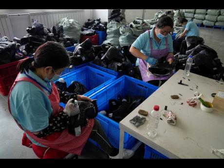 Workers assembly ice-skating shoes at a manufacturing factory in the ice and snow sports equipment industry park in Zhangjiakou, in northwestern China’s Hebei province, on July 15. 