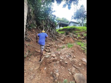 Osbourne McKenzie climbs the hillside towards his home in Stewart Field, St Thomas, last Thursday.