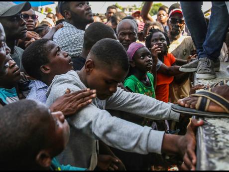 A youth cries as he waits for a sack of rice being distributed to residents in Les Cayes, Haiti, on Monday, August 16, two days after a 7.2-magnitude earthquake struck the southwestern part of the hemisphere’s poorest nation. 