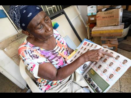 Ellin Williams, grandmother of 17-year-old D’Marko Levy, points him out in a yearbook at her Patrick City on Monday. Williams was killed on Gore Terrace in a botched phone transaction on Saturday.