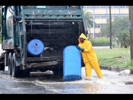 This NSWMA worker was seen collecting garbage in the Corporate Area during heavy rainfall recently.