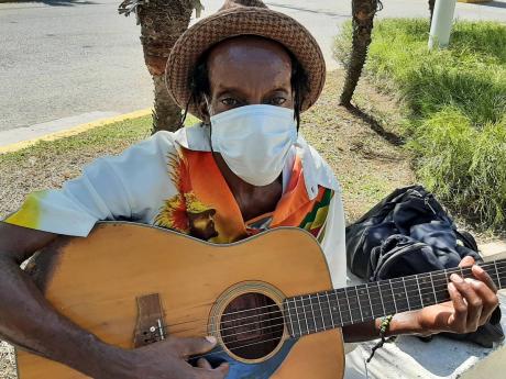 Morris James plays his guitar along the promenade which leads to the cruise ship pier.
