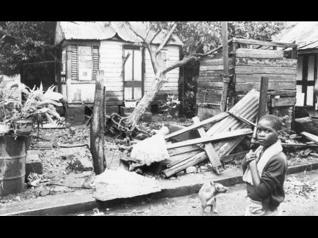 A young boy looks at the rubble that remained of his house following the passage of Hurricane Gilbert on Monday, September 12, 1988.