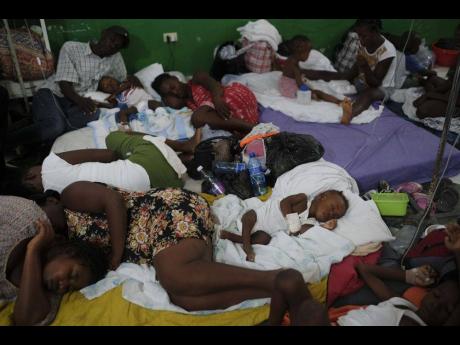 Injured children and their parents sleep on mattresses on the floor of the Immaculee Conception Hospital in Les Cayes, Haiti, on Monday.