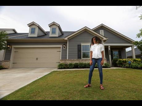 Credit: AP
Crystal Marie McDaniels poses in front of her home in Charlotte, North Carolina, on Friday, July 9. McDaniels said buying a house was crucial for her because she wants to pass on wealth to her son some day, giving him an advantage she never had.