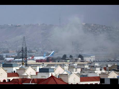 Smoke rises from a deadly explosion outside the airport in Kabul, Afghanistan, yesterday. 