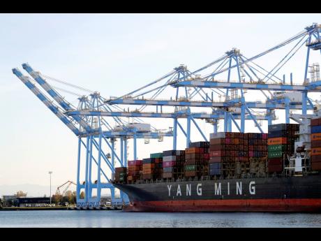 
In this file photo cargo cranes take containers off of a Yang Ming Marine Transport Corporation boat at the Port of Tacoma in Tacoma, Washington. Last year it cost about US$ 2,500 to ship a 40 foot container from China to Kingston. Now that same container