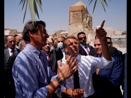 French President Emmanuel Macron (centre) at the landmark al-Nuri Mosque compound, which was damaged in the battle with Islamic State militants in 2017 and is being rebuilt, in Mosul, northern Iraq.