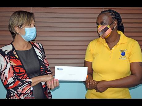Credit: Contributed Christine Watson (right) childcare manager of Sophie’s Place, an arm of the Mustard Seed Communities, receives a donation from Tanya Pringle (left), executive, corporate communications, The Jamaica National Group.