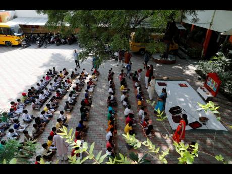 Students attend morning assembly on the first day of the partial reopening of schools in Prayagraj, India, on Wednesday, September 1. More students in India will be able to step inside a classroom for the first time in nearly 18 months on Wednesday, as aut