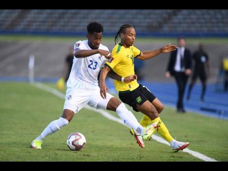 Jamaica's Bobby Reid (right) is bundled off the ball by Panama's Michael Murillo during their FIFA World Cup qualifying match at the National Stadium on Sunday afternoon.