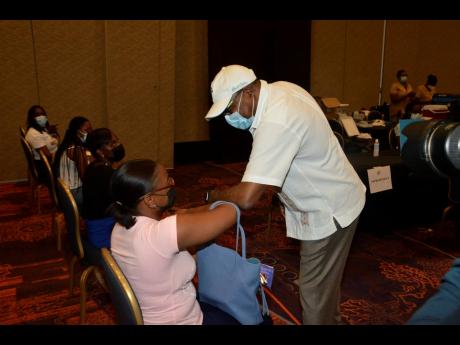 Credit: Contributed Minister of Tourism Edmund Bartlett (right), greets tourism entrepreneur, Joelle Miller, who is waiting to be vaccinated at the Tourism Vaccination Task Force’s COVID-19 Vaccination Blitz, held at Moon Palace in Ocho Rios, St Ann, on Friday, September 3.