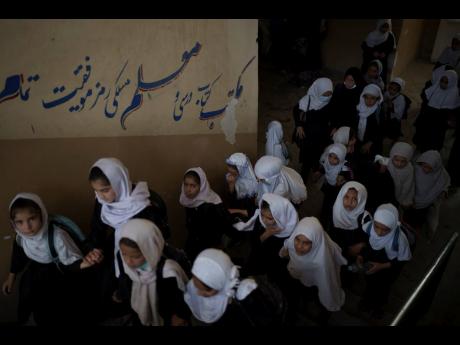 Girls walk upstairs as they enter a school before class in Kabul. The Taliban have suggested they have changed, including in their attitudes towards women. However, women have been banned from sports.