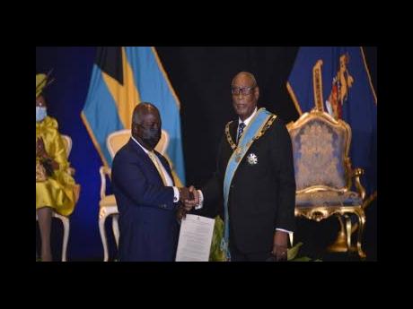 Prime Minister Philip Davis (left), receives his instruments of appointment from Governor General Sir Cornelius Smith on Saturday.
