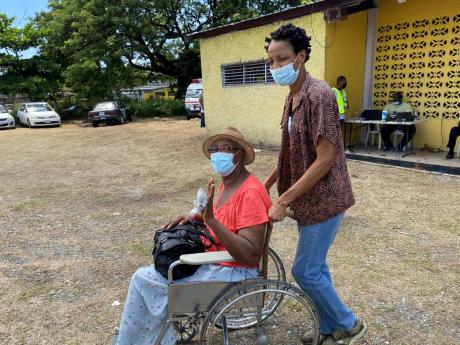 Credit: Ainsworth Morris Wheelchair-mobile Rosabelle Campbell with her daughter, Lavern Campbell, at the Pembroke Hall Community Centre after being vaccinated with her first dose of the AstraZeneca vaccine.