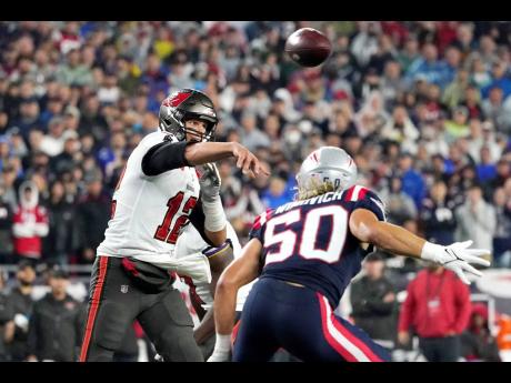 Tampa Bay Buccaneers quarterback Tom Brady (left) throws a pass while pressured by New England Patriots defensive end Chase Winovich during the first half of an NFL football game in Foxborough, Massachusetts yesterday.