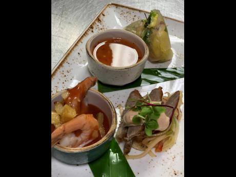 Appetiser trio of shrimp and cocktail grilled pineapple; bourbon cocktail sauce; ‘Jamaisan’ summer roll ackee; and roasted peanuts, veggies, herbs, sweet chilli sauce smoked duck breast, with Thai green papaya slaw and sriracha mayo.