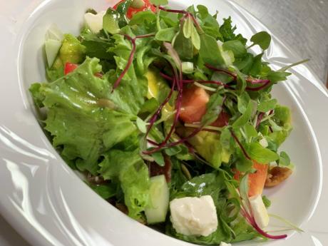 Couples garden greens with avocado, cherry tomatoes, cucumber, crunchy seeds and nuts, dried apples, bacon, feta cheese and a passion-fruit vinaigrette.