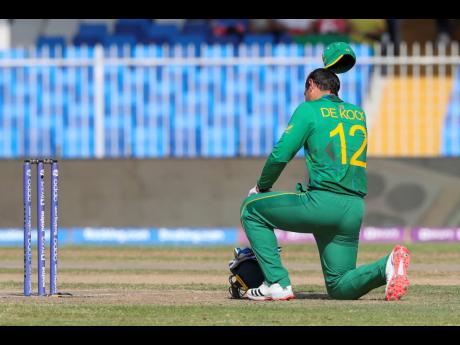 South Africa's Quinton de Kock kneels in support of the Black Lives Matter movement ahead of this morning's Twenty20 World Cup cricket match between South Africa and Sri Lanka in Sharjah, United Arab Emirates.