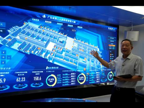 Tian Junzhang, president of Guangdong Second Provincial General Hospital, gestures in front of the monitoring screen of the hospital’s cloud data centre ‘smart brain’ in Guangzhou, in southern China’s Guangdong province, Sunday, September 26, 2021.
