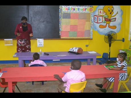 Susan Davis, principal of the St James-based Sudbury All-Age and Infant School, interacting with some of her students during a class on Monday as the institution reopened for face-to-face classes.