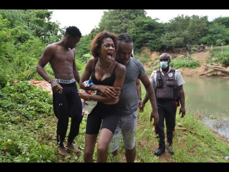 Daliah Baccas bawls moments after the body of her 14-year-old sister, Damoya Grant, was recovered from the Rio Cobre on Tuesday. Damoya and friends reportedly went for a swim on Monday but she got into difficulty and drowned.