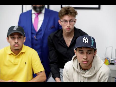 Credit: AP From left: Jonathan Espinoza, Eligio Garcia and Bryan Espinoza, who all attended the Travis Scott concert at Astroworld, listen during a news conference at the Rick Ramos Law office, on Tuesday, in Houston. Ramos is expected to file a lawsuit on behalf of