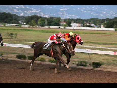 Credit: Anthony Minott
FURTHER AND BEYOND (left), ridden by Linton Steadman, wins the Jamaica Cup ahead of BILLY WHIZZ (Dick Cardenas) at Caymanas Park yesterday.