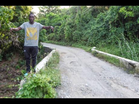 Jevawn Henry stands on the bridge leading into Llandewey, St Thomas, which collapsed last November after rushing water from heavy rain eroded a section under the bridge. Henry believes that another heavy rainfall could take away the bridge completely.