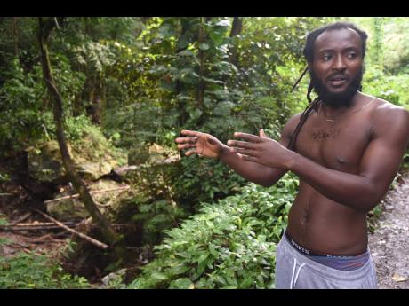 Credit: Ian Allen Sandrae Walker, a resident of Ham Walk, St Catherine North Eastern, shows the boulders that block the free flow of the Ital River, which causes flooding in the district during heavy rains.