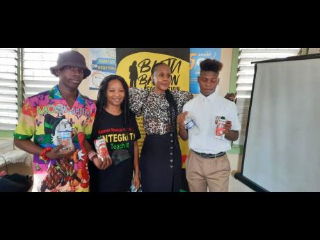 
From left:  Paul Williamson (student), Kamau Mahakoe (facilitator/math specialist), Rosemary Duncan(director Buju Banton Foundation), and Tajay Bailey (student) pose for a photograph at the math workshop.