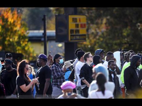 Dozens of onlookers gathered at the scene where rapper Young Dolph was killed at a cookie shop.